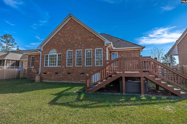 rear view of house featuring a wooden deck and a yard