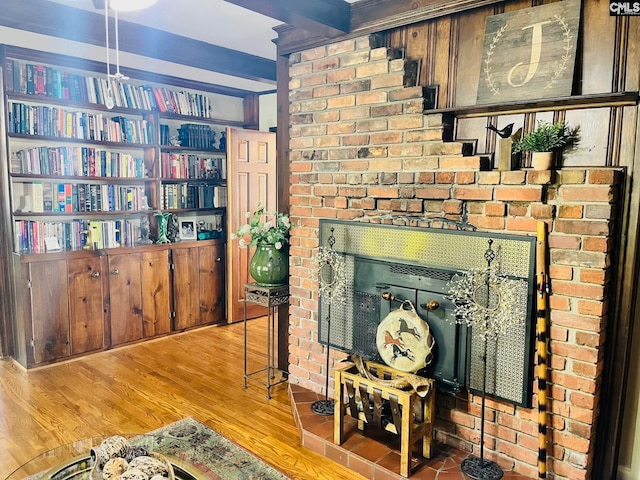 interior details featuring beamed ceiling, wood-type flooring, and a fireplace