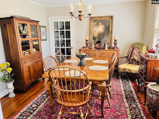 dining space featuring dark hardwood / wood-style flooring, crown molding, and an inviting chandelier