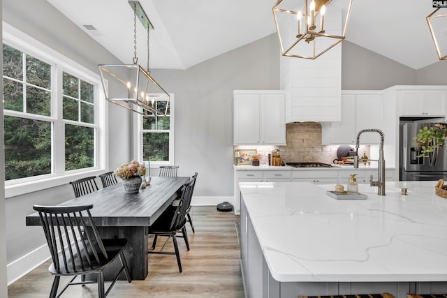 kitchen featuring pendant lighting, an island with sink, and appliances with stainless steel finishes