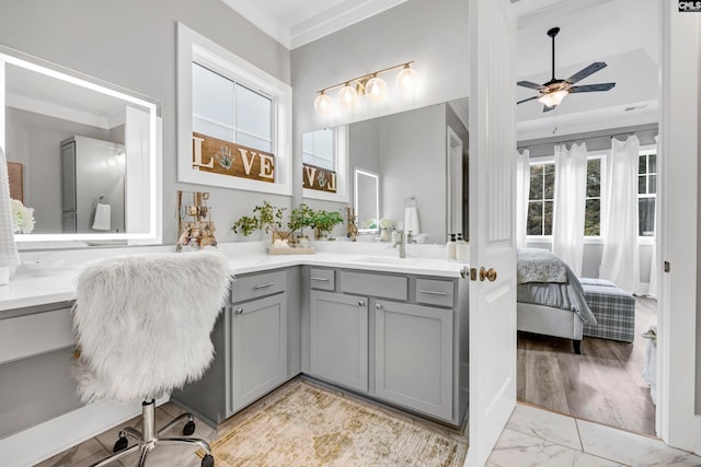 bathroom featuring hardwood / wood-style floors, vanity, ceiling fan, and ornamental molding