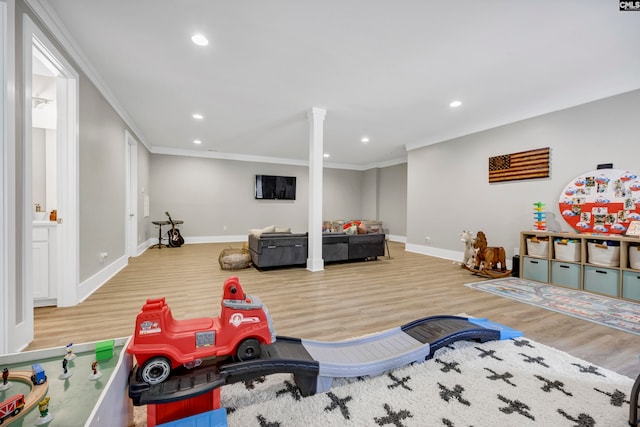 rec room with wood-type flooring, crown molding, and decorative columns