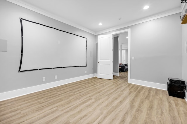 cinema room with ornamental molding and light wood-type flooring