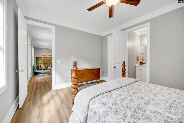 bedroom featuring connected bathroom, light hardwood / wood-style flooring, ceiling fan, and crown molding