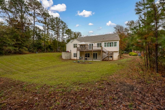 rear view of house featuring a deck and a yard