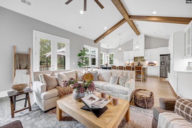 living room featuring high vaulted ceiling, french doors, ceiling fan, light wood-type flooring, and beam ceiling