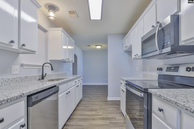 kitchen featuring white cabinetry, sink, appliances with stainless steel finishes, and light hardwood / wood-style flooring