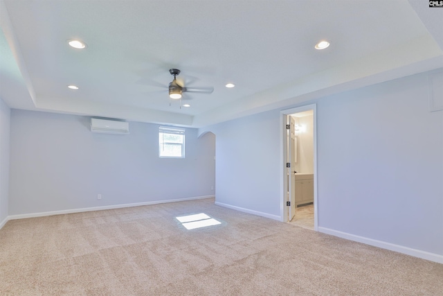 basement with light carpet, a wall mounted AC, and ceiling fan