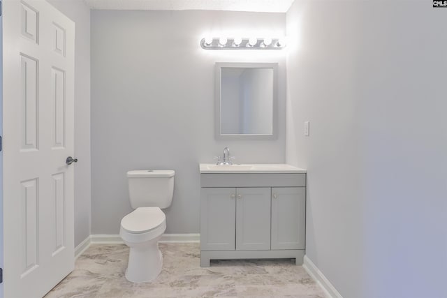 bathroom with vanity, toilet, and a textured ceiling