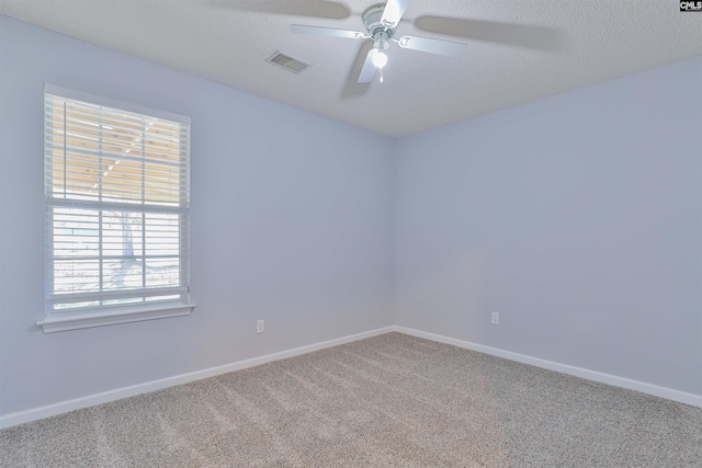 carpeted empty room with ceiling fan and a textured ceiling