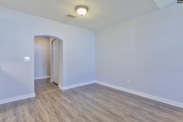 unfurnished room featuring hardwood / wood-style floors and a textured ceiling