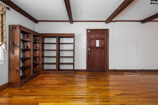 entryway with beamed ceiling, ornamental molding, and hardwood / wood-style flooring