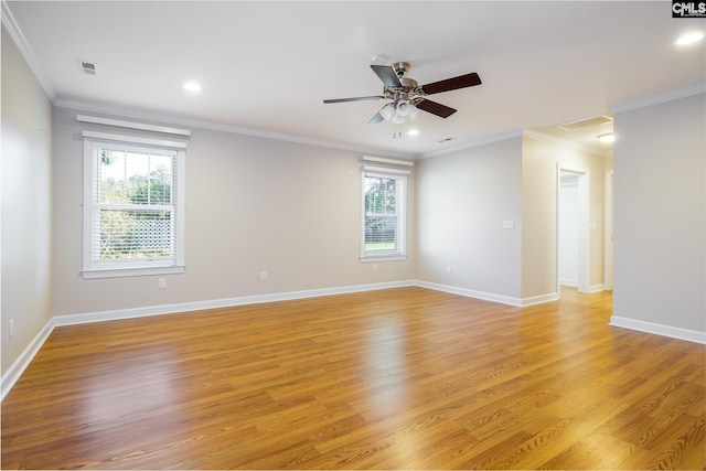 spare room featuring light hardwood / wood-style floors, crown molding, and a wealth of natural light