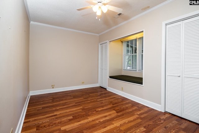 unfurnished bedroom with ceiling fan, crown molding, dark wood-type flooring, and a textured ceiling