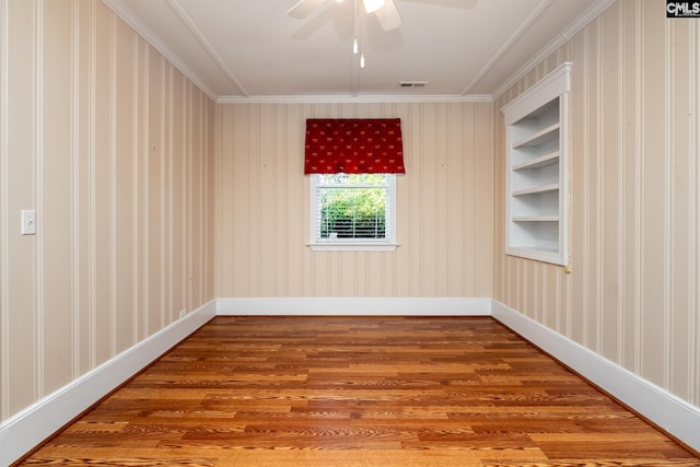 spare room with wood-type flooring, ceiling fan, and ornamental molding