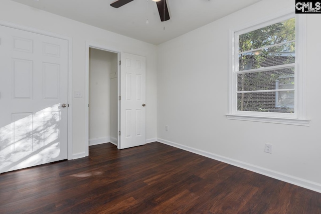 unfurnished bedroom with ceiling fan and dark wood-type flooring