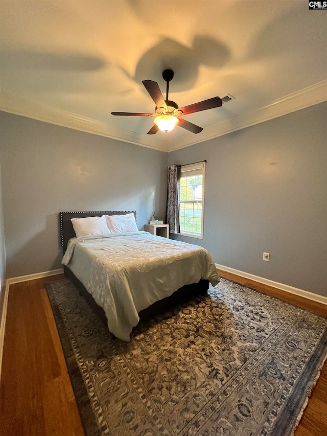 bedroom featuring ceiling fan, wood-type flooring, and ornamental molding
