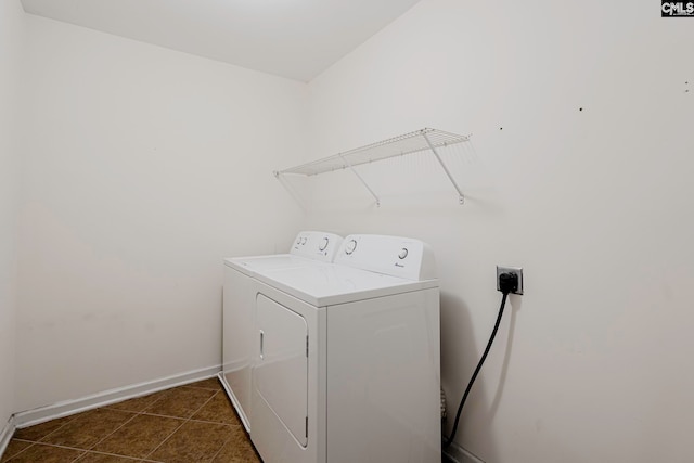 laundry area with dark tile patterned flooring and washing machine and dryer