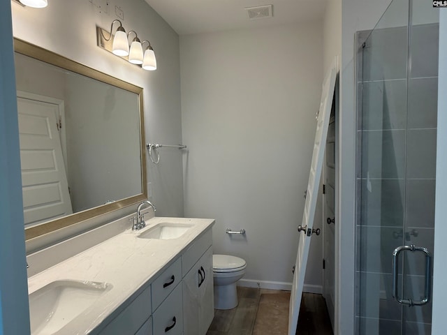 bathroom with hardwood / wood-style flooring, vanity, toilet, and an enclosed shower