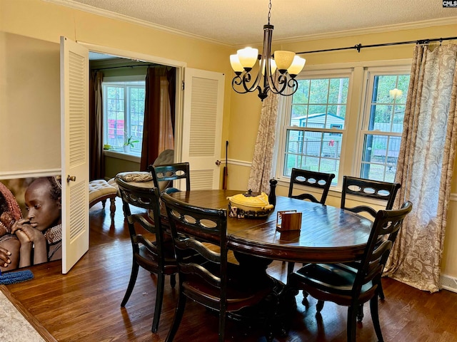 dining area featuring a textured ceiling, dark hardwood / wood-style floors, a wealth of natural light, and ornamental molding