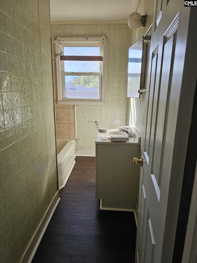 bathroom with vanity, bathing tub / shower combination, tile walls, a textured ceiling, and wood-type flooring