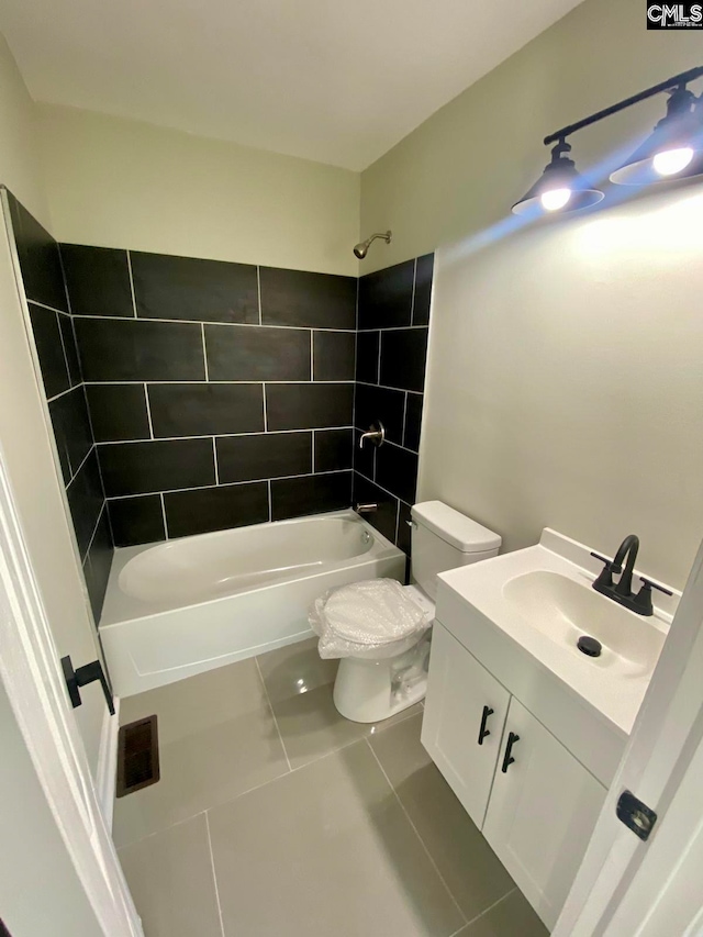 full bathroom with tile patterned floors, tiled shower / bath combo, toilet, and vanity