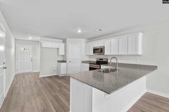 kitchen with white cabinets, light wood-type flooring, sink, and appliances with stainless steel finishes