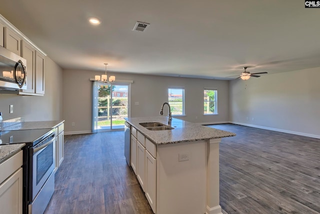 kitchen with sink, dark wood-type flooring, stainless steel appliances, a center island with sink, and white cabinets