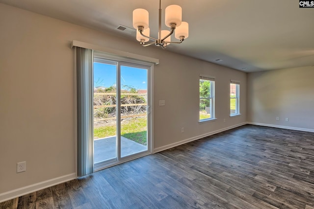 empty room with dark hardwood / wood-style flooring and a chandelier