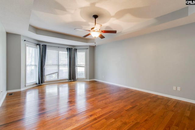 unfurnished room featuring hardwood / wood-style floors, ceiling fan, and a healthy amount of sunlight