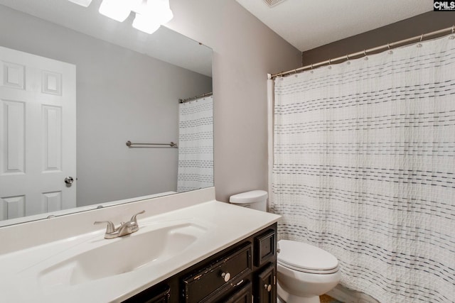 bathroom with vanity, toilet, and a textured ceiling