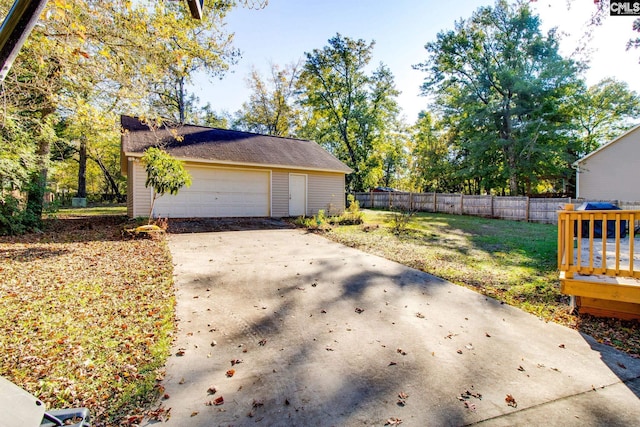 view of side of home featuring a yard, a garage, and an outdoor structure