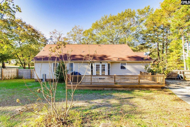 back of house featuring a lawn and a wooden deck