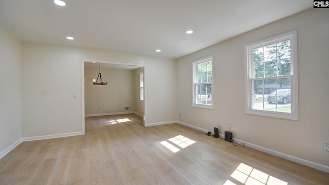 empty room featuring light hardwood / wood-style floors and an inviting chandelier