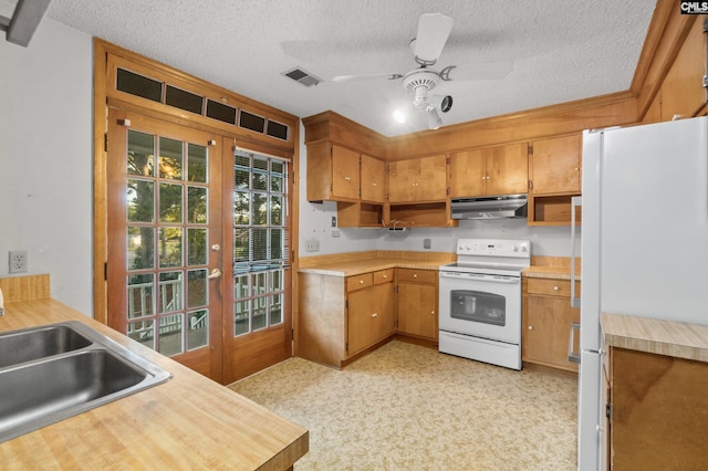 kitchen featuring ceiling fan, sink, white appliances, and a textured ceiling