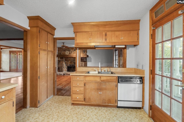 kitchen with dishwasher, light wood-type flooring, a textured ceiling, and sink