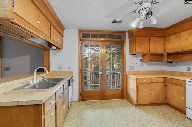 kitchen featuring french doors, a textured ceiling, light colored carpet, and sink