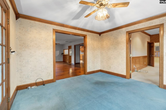 empty room featuring a healthy amount of sunlight, hardwood / wood-style flooring, ceiling fan, and ornamental molding