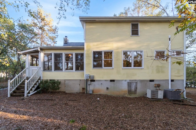 rear view of house featuring a sunroom and central air condition unit