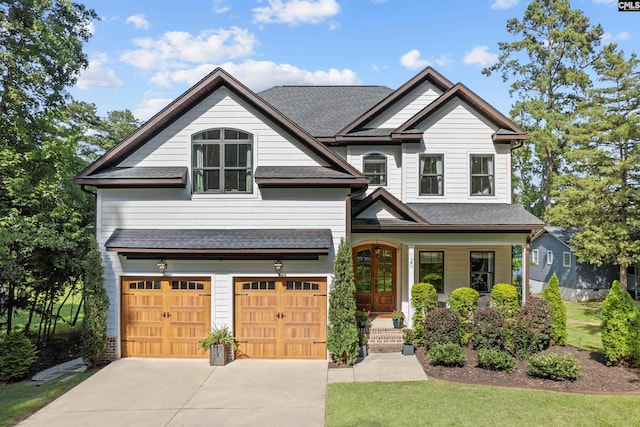 craftsman house with a garage, a front yard, and french doors