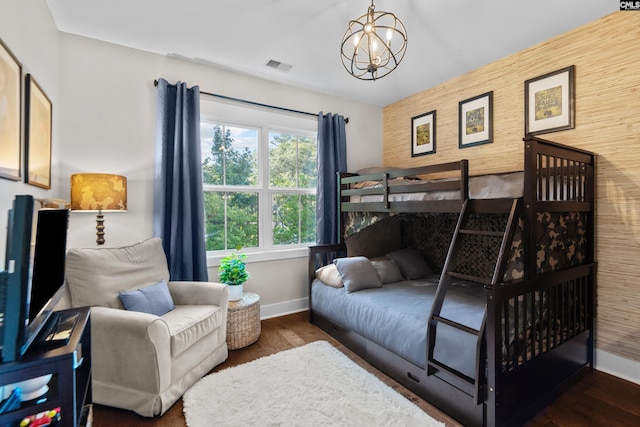 bedroom with a notable chandelier and dark wood-type flooring