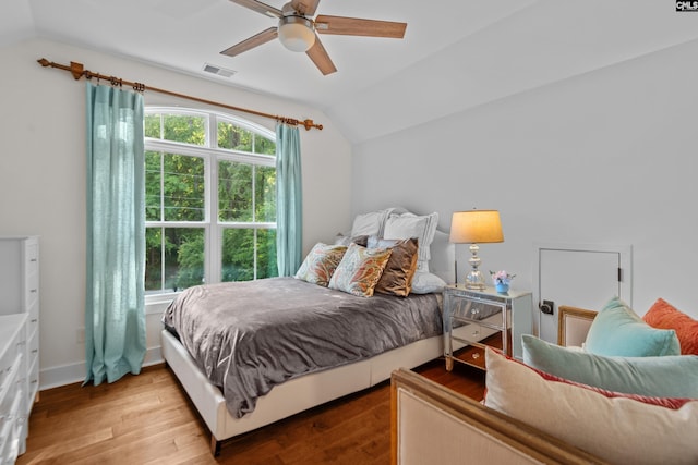 bedroom with ceiling fan, vaulted ceiling, and light hardwood / wood-style flooring