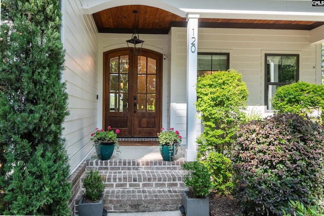 view of exterior entry with french doors and a porch