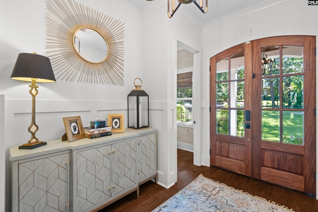 foyer entrance with plenty of natural light, dark wood-type flooring, french doors, and ornamental molding