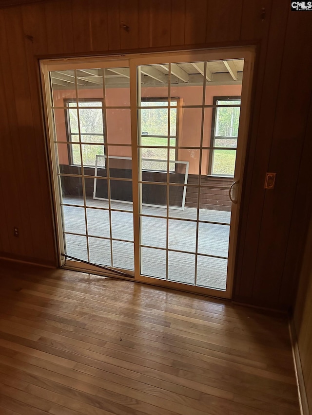 doorway to outside with wood walls and hardwood / wood-style flooring