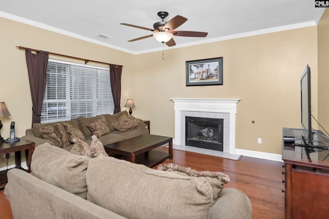 living room featuring a fireplace, hardwood / wood-style floors, ceiling fan, and ornamental molding