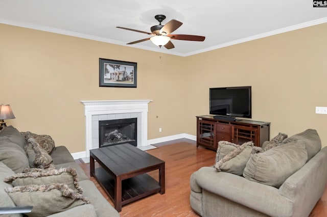 living room featuring a fireplace, hardwood / wood-style floors, ceiling fan, and ornamental molding