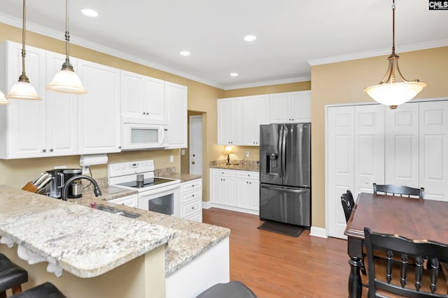 kitchen featuring sink, dark wood-type flooring, decorative light fixtures, white appliances, and white cabinets