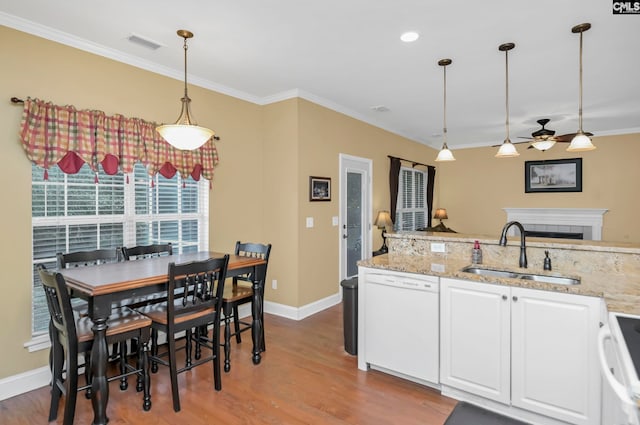 kitchen featuring sink, decorative light fixtures, white appliances, white cabinets, and hardwood / wood-style flooring