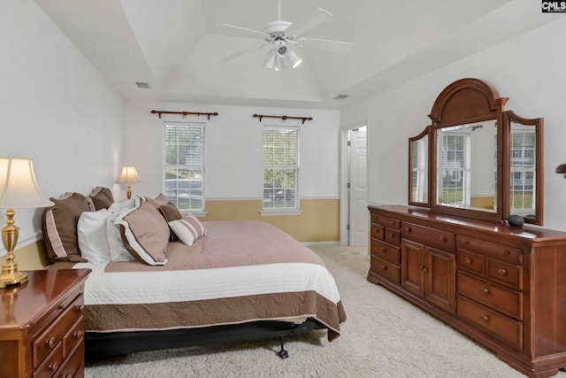 bedroom featuring a tray ceiling, light carpet, ceiling fan, and lofted ceiling